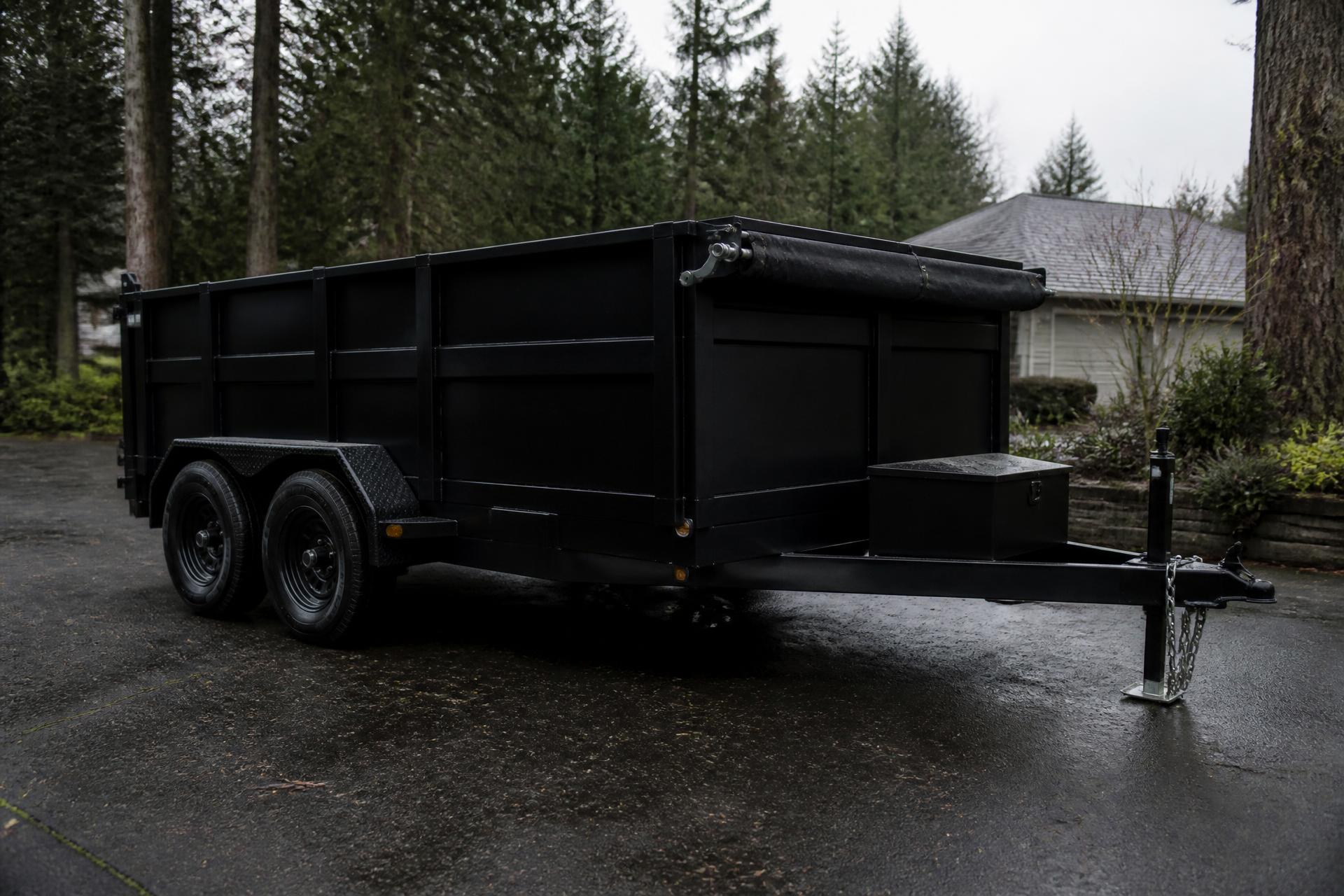 Anderson's Junk Removal crew loading a heavy-duty dump trailer in the Pacific Northwest